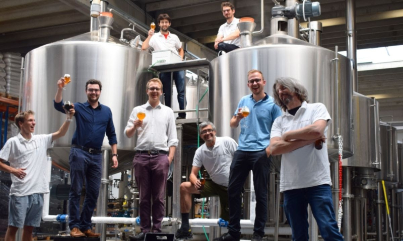 Acht Belgische brouwers met bier in de hand in de Beerselect brouwerij